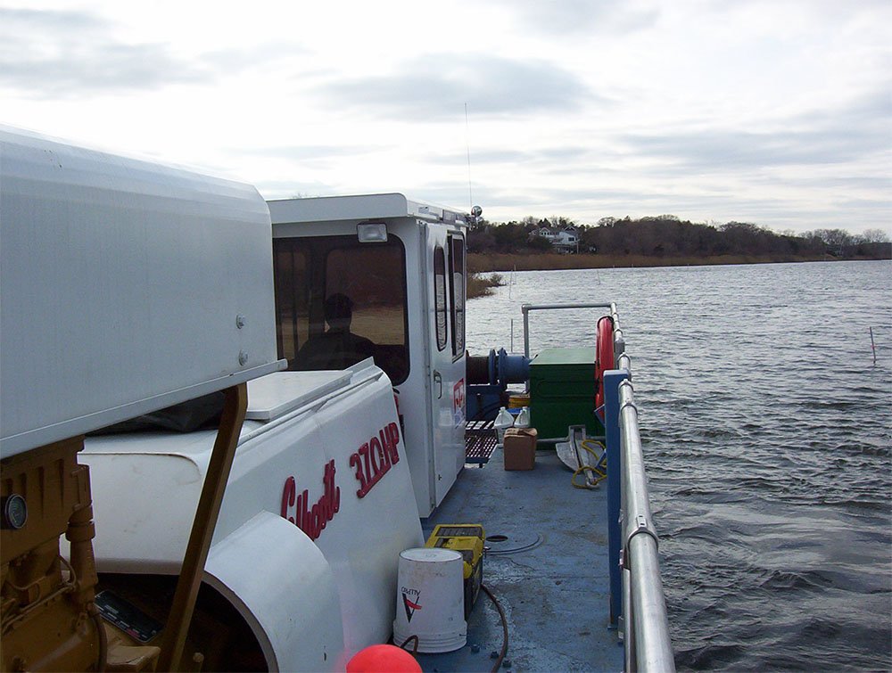 on the deck of a dredge on a lake